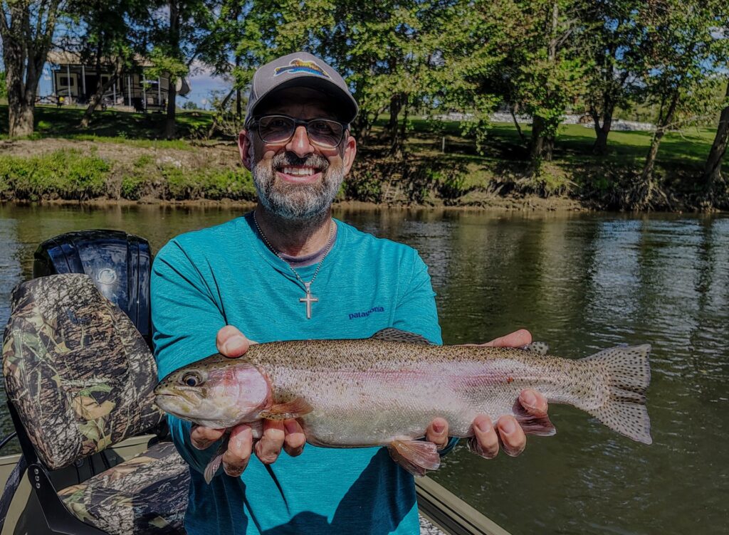 Angler holding a large Rainbow Trout caught on the Cumberland River in Burkesville KY.