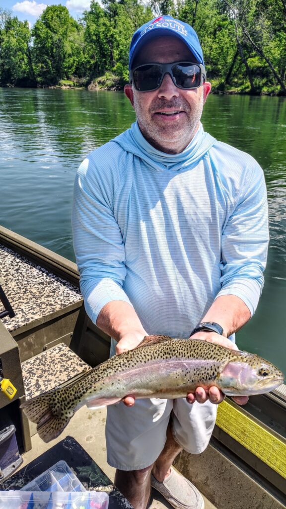 A guided fly fishing client holding a healthy Cumberland River Rainbow Trout caught on a caddis pattern.