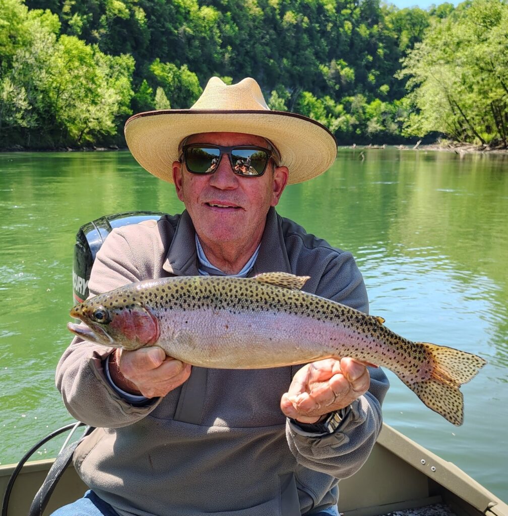 A man holding a large rainbow trout caught on the Cumberland River during a guided fly fishing trip