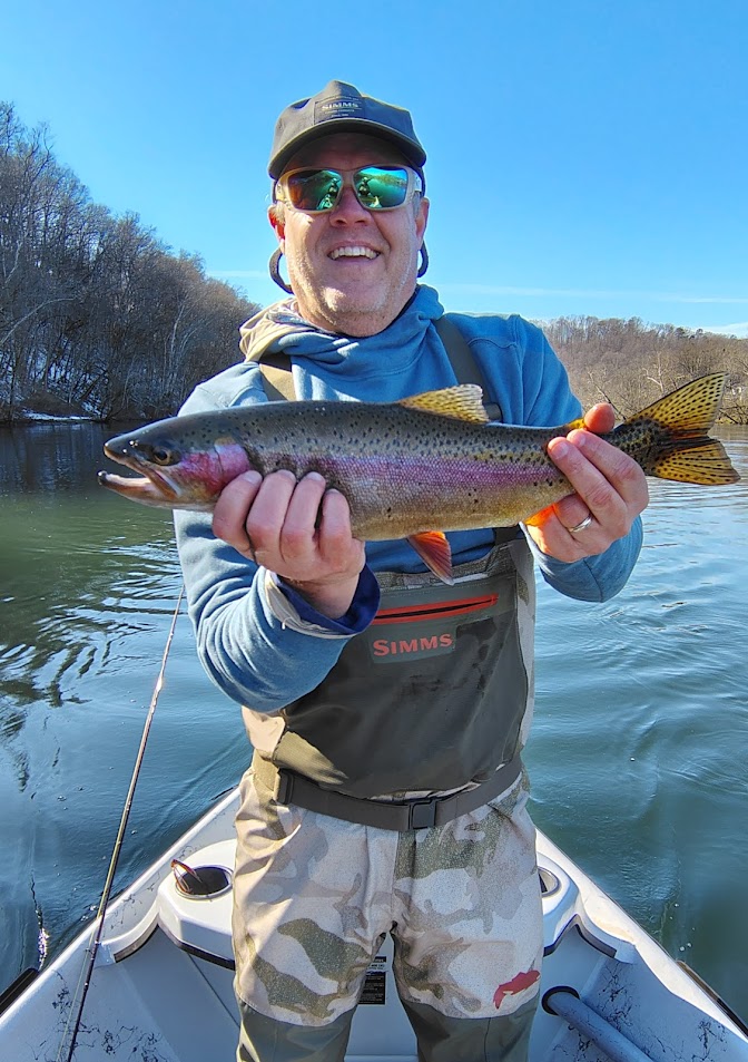 A happy fly fishing client proudly holding a large Rainbow Trout caught on a guided boat trip on the Clinch River.