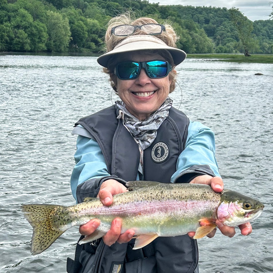A smiling angler holding a vibrant rainbow trout caught on a dry fly during a hatch on the Holston River.