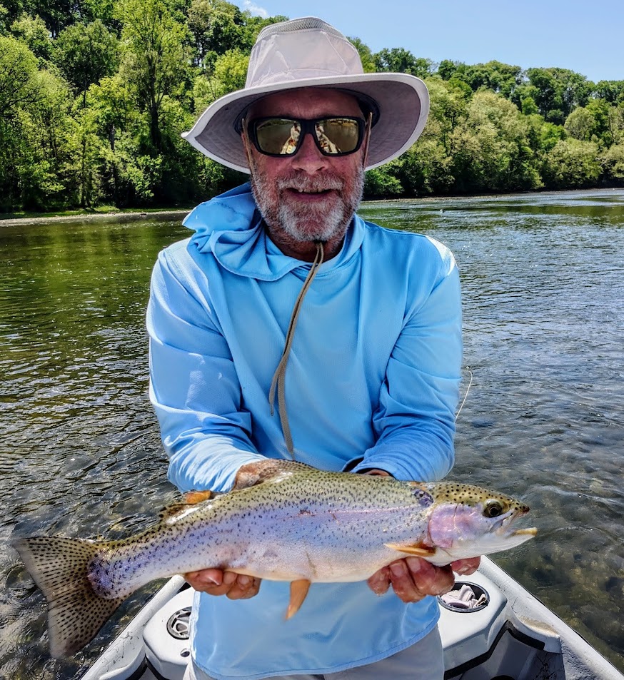 A happy fly fishing client holding a beautiful Rainbow Trout caught on a guided boat trip on the Holston River.