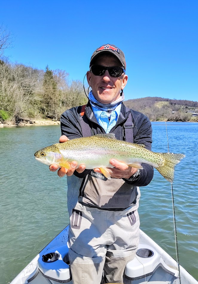 A happy fly fishing client holding a beautiful Rainbow Trout caught during a guided drift boat float trip on the Holston River.