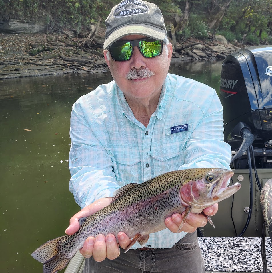 Angler proudly holding a large rainbow trout landed on a guided Cumberland River fly fishing trip