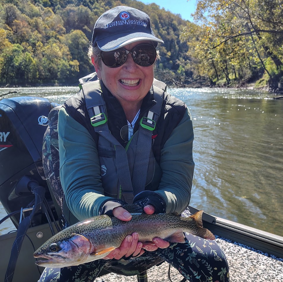 Angler holding a large rainbow trout caught on a guided fly fishing trip on the Cumberland River in Kentucky.