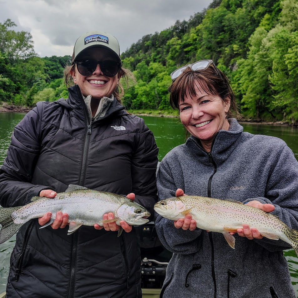 Two fly fishing clients smiling while holding a large rainbow trout on the Cumberland River