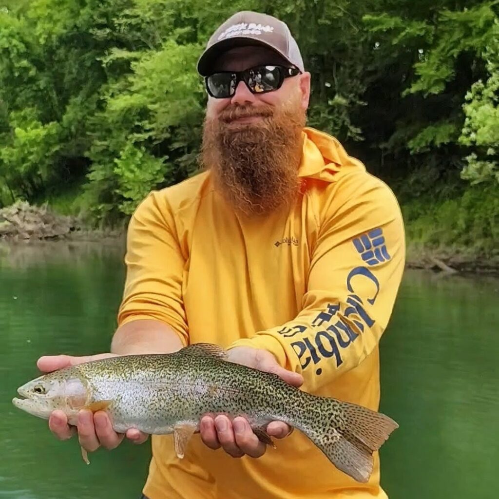 A happy fly fishing client holding a large, healthy rainbow trout on the Cumberland River.