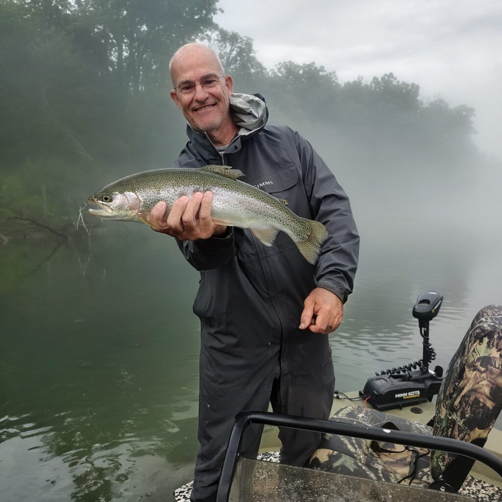 A man holding a beautiful rainbow trout caught on the Cumberland River in Burkesville, Kentucky.