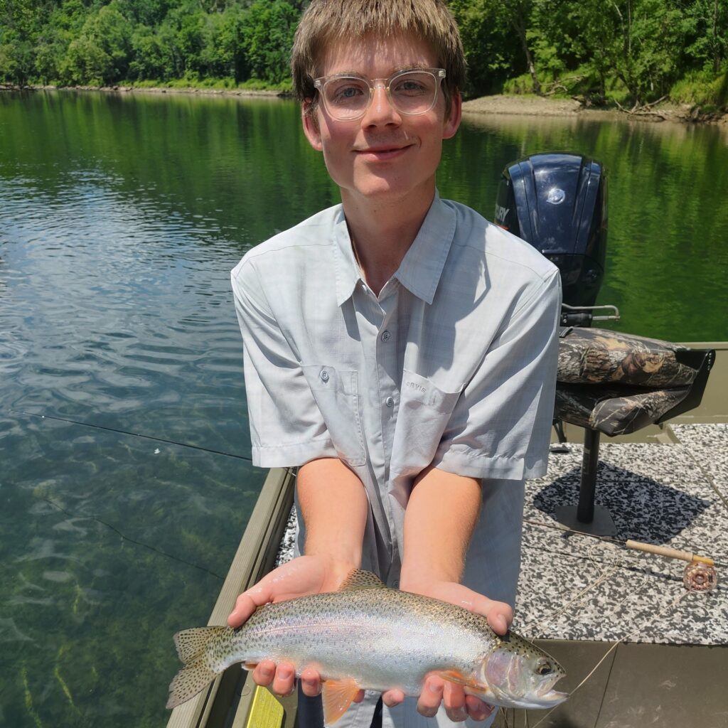 A Young man holding a healthy Rainbow Trout caught on the Cumberland River.