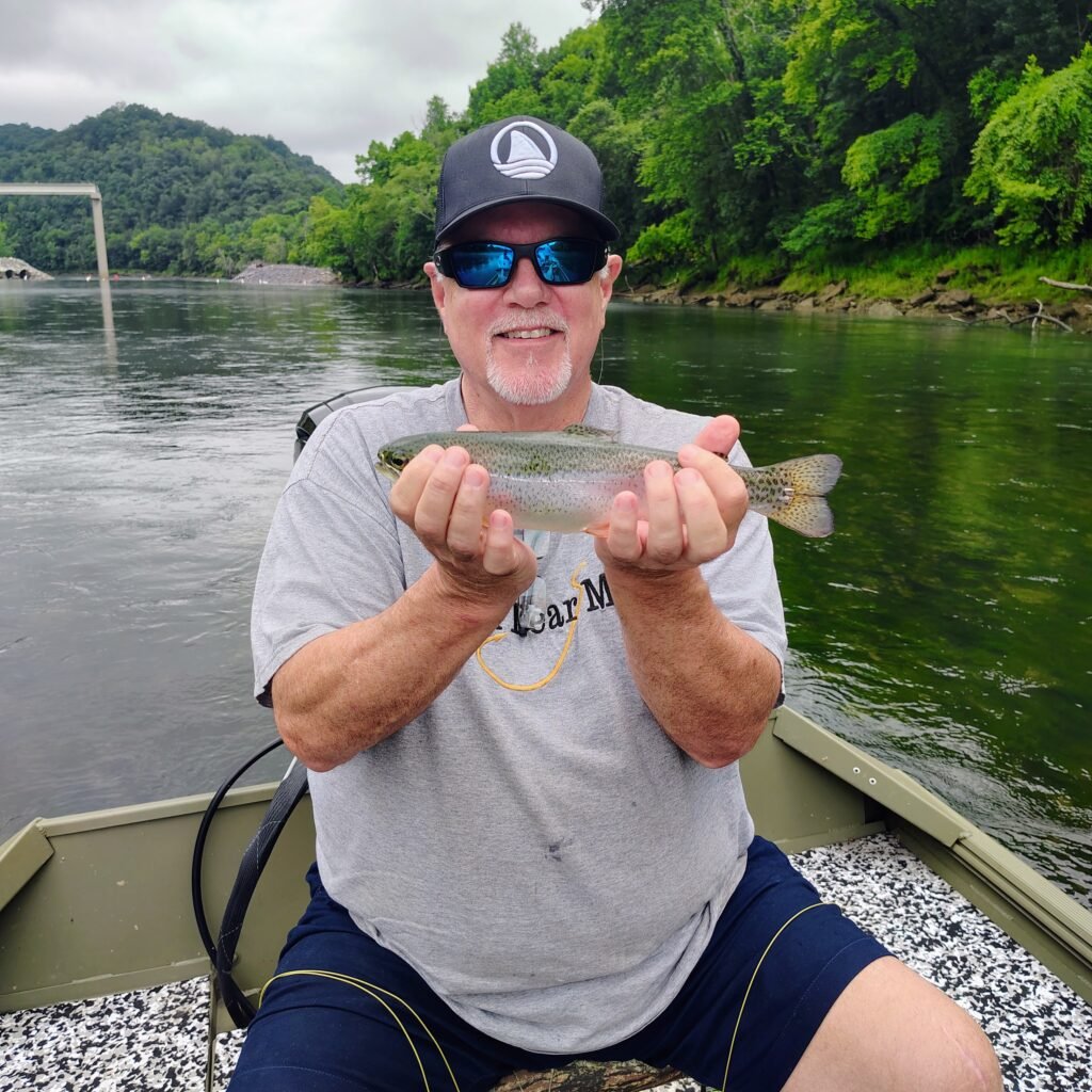 A happy angler displaying his first trout caught on a fly rod during a guided drift boat trip on the Cumberland River.