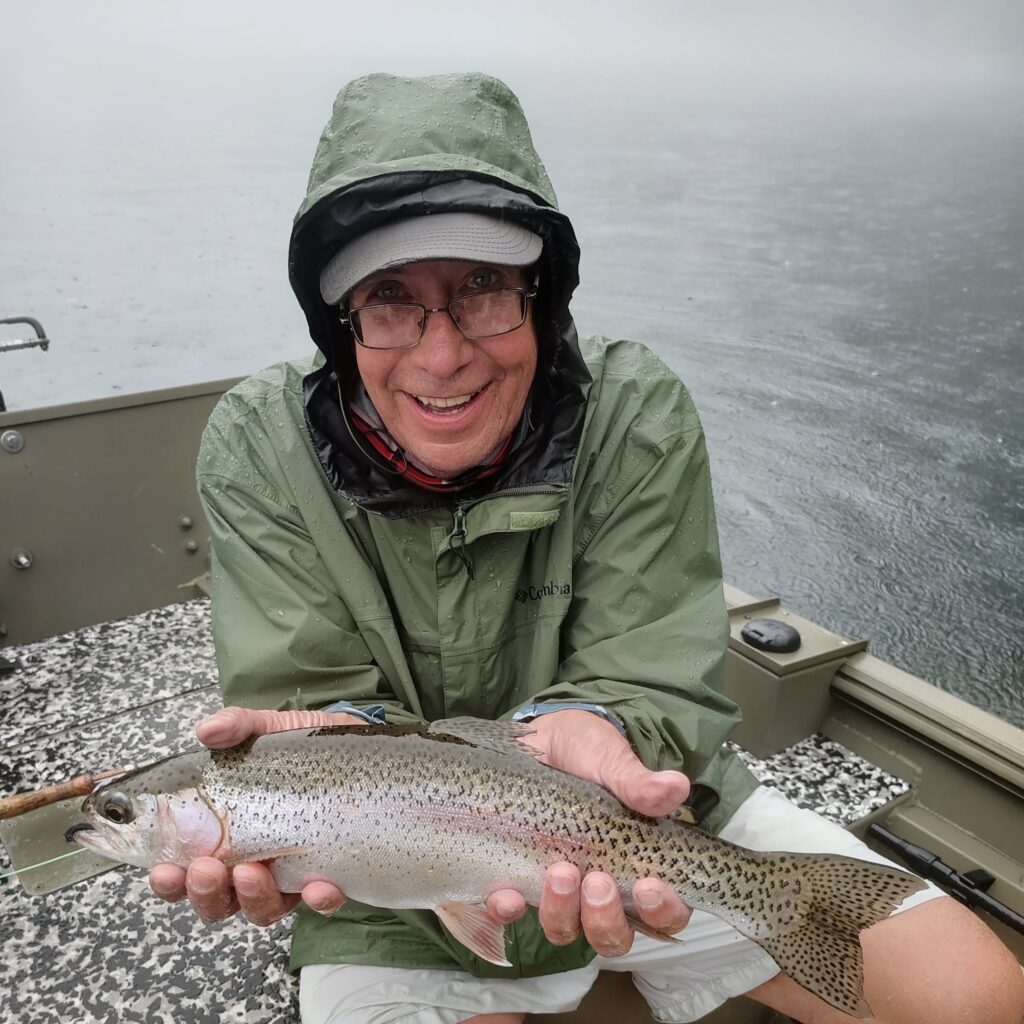 A professional fly fishing guide and client in a boat on the Cumberland River during a guided trip.
