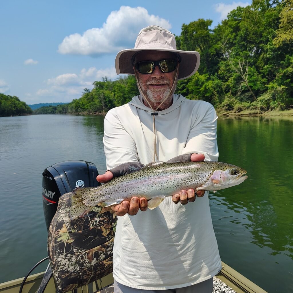 A vibrant rainbow trout held by an angler on the Cumberland River in Burkesville, Kentucky
