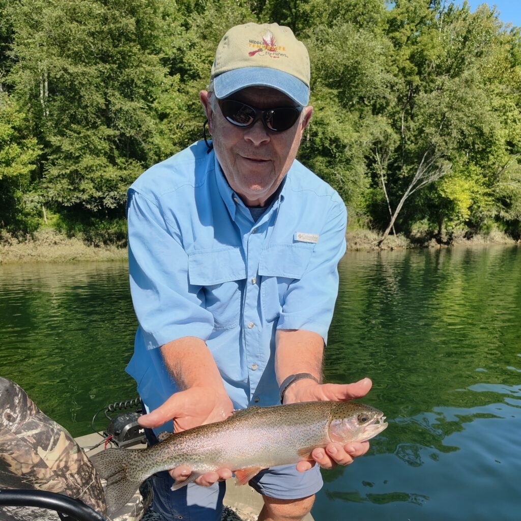 A vibrant rainbow trout held by an angler on a guided trip on the Cumberland River in Burkesville, Kentucky