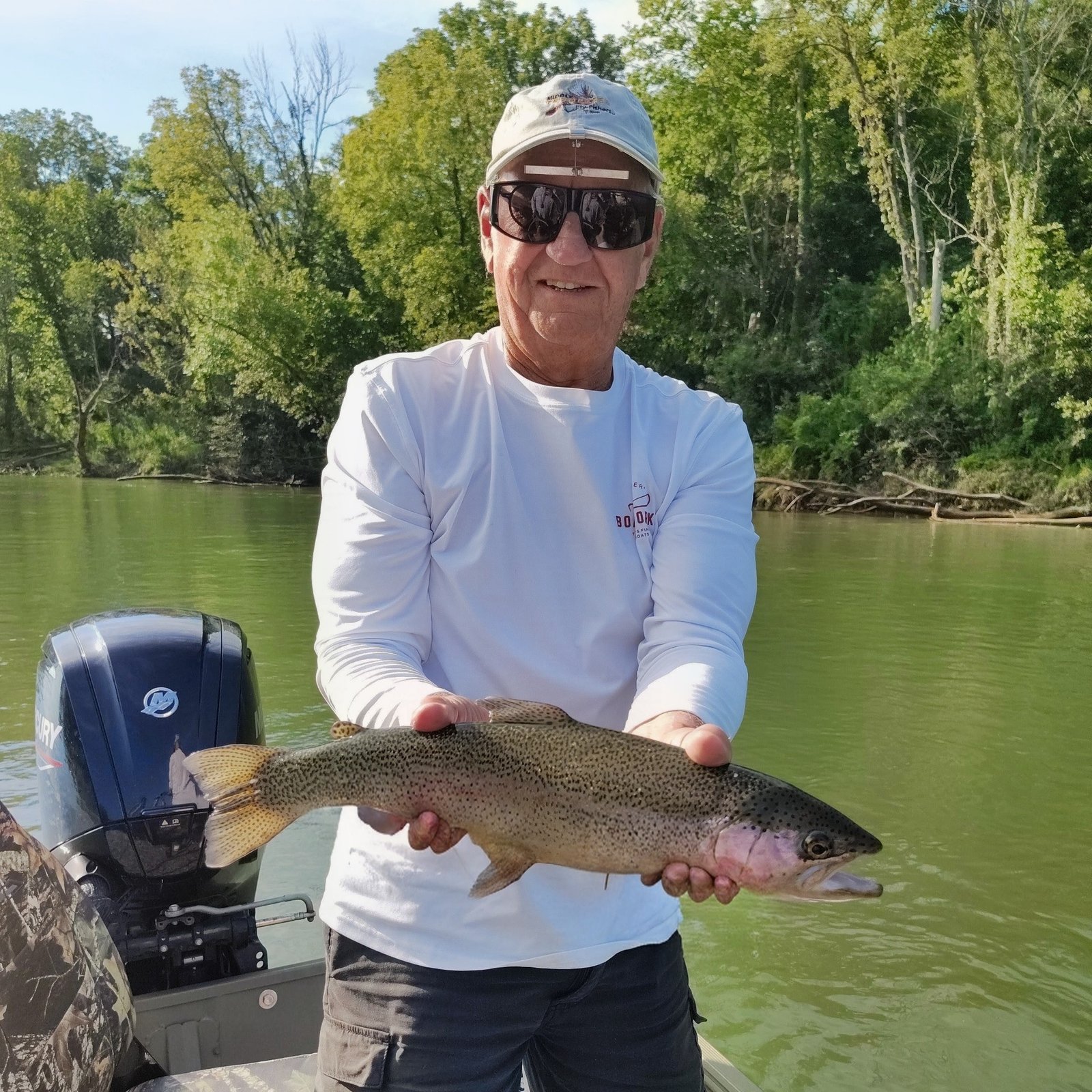 A client posing with a healthy rainbow trout on a jet boat during a Cumberland River guided trip
