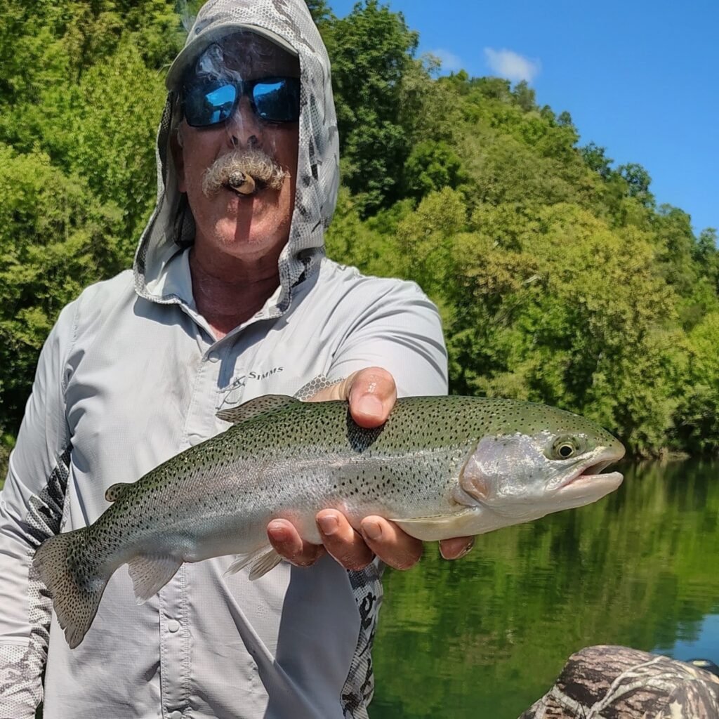 Angler enjoying a cigar and fly fishing on a guided trip on the Cumberland River in Burkesville, Kentucky