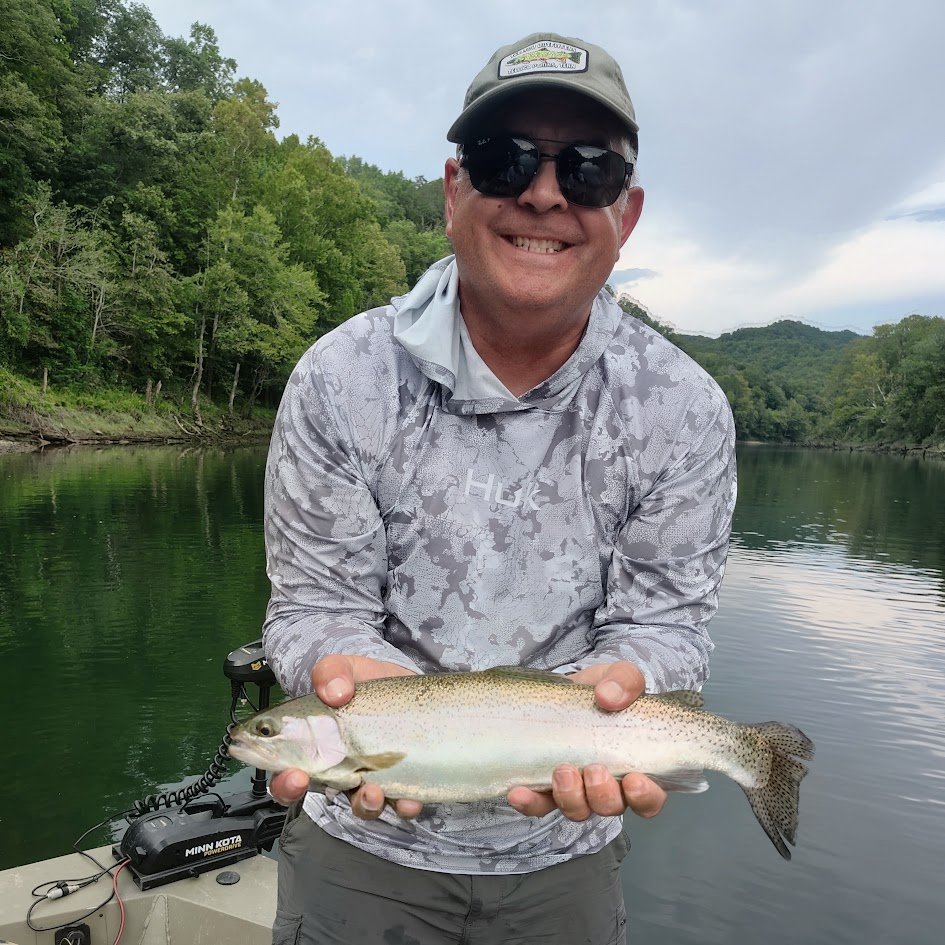 A vibrant rainbow trout held by an angler on the Cumberland River in Burkesville, Kentucky