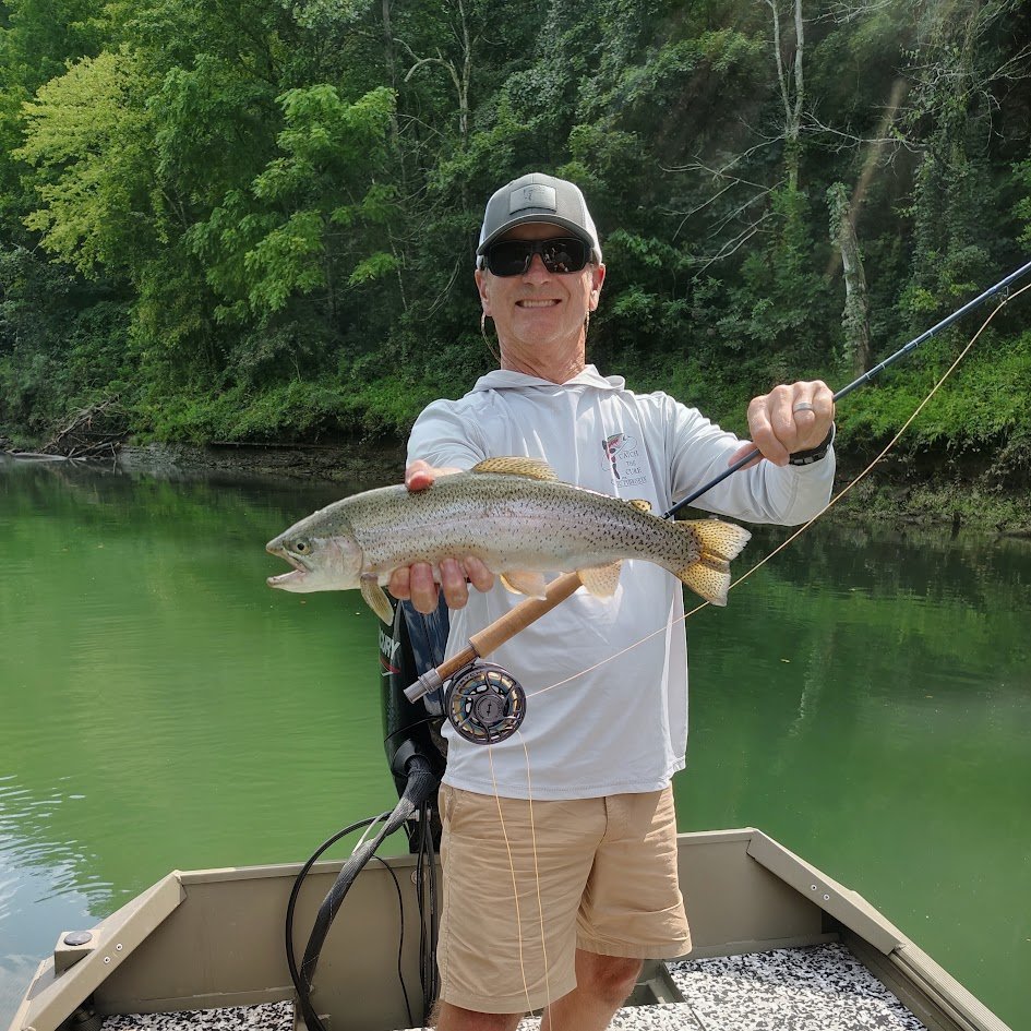 A happy fly fisherman holding a Cumberland River Rainbow Trout