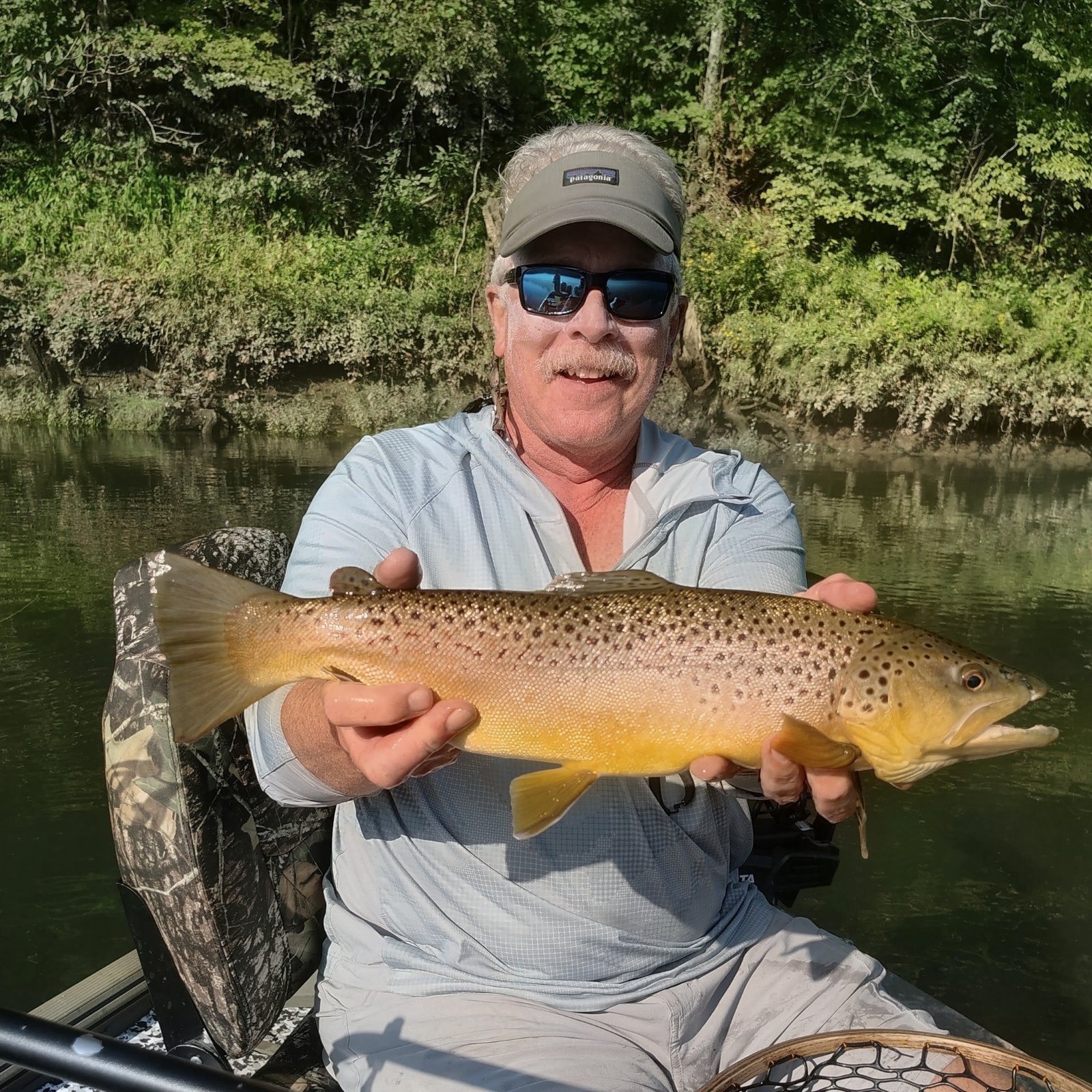 Angler holding a trophy brown trout caught on a dry fly during a guided trip on the Cumberland River in Burkesville, Kentucky