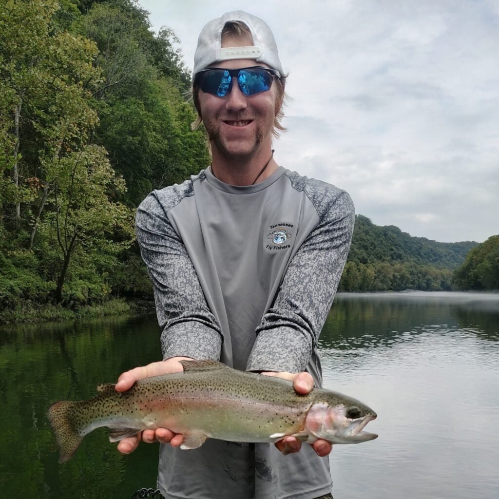 Angler holding a large rainbow trout caught on a streamer pattern during a guided fly fishing trip on the Cumberland River near Burkesville, Kentucky