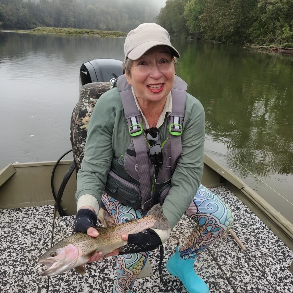 Angler holding a vibrant rainbow trout caught on a guided fly fishing trip on the Cumberland River in Burkesville, Kentucky