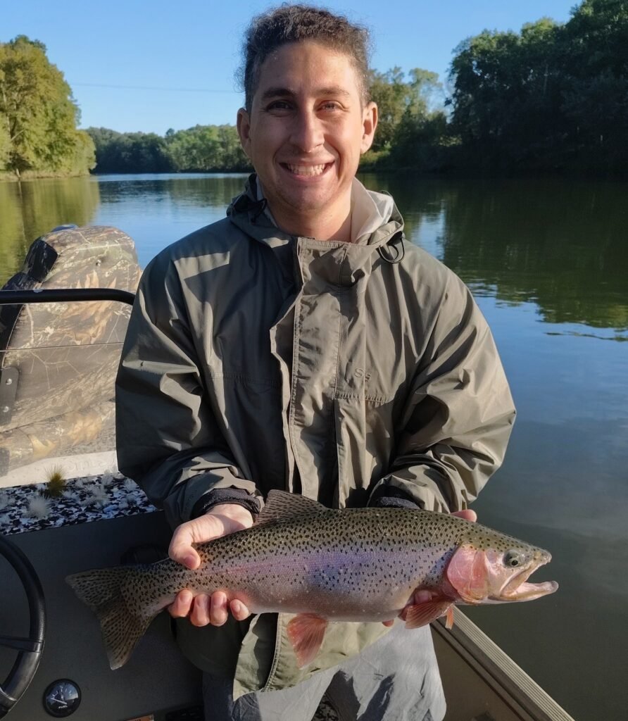 An angler holding a large, healthy rainbow trout caught on a guided fly fishing trip on the Cumberland River in Burkesville, Kentucky.